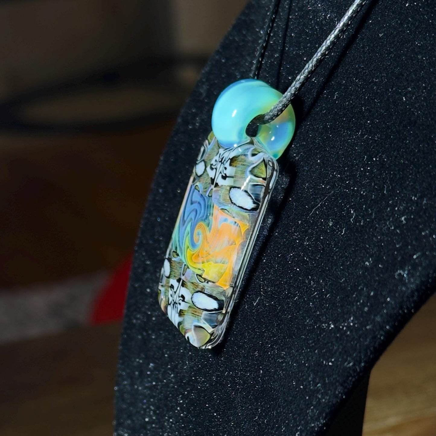 Color changing fume and murrine chip stack blown glass pendant with lucid bail